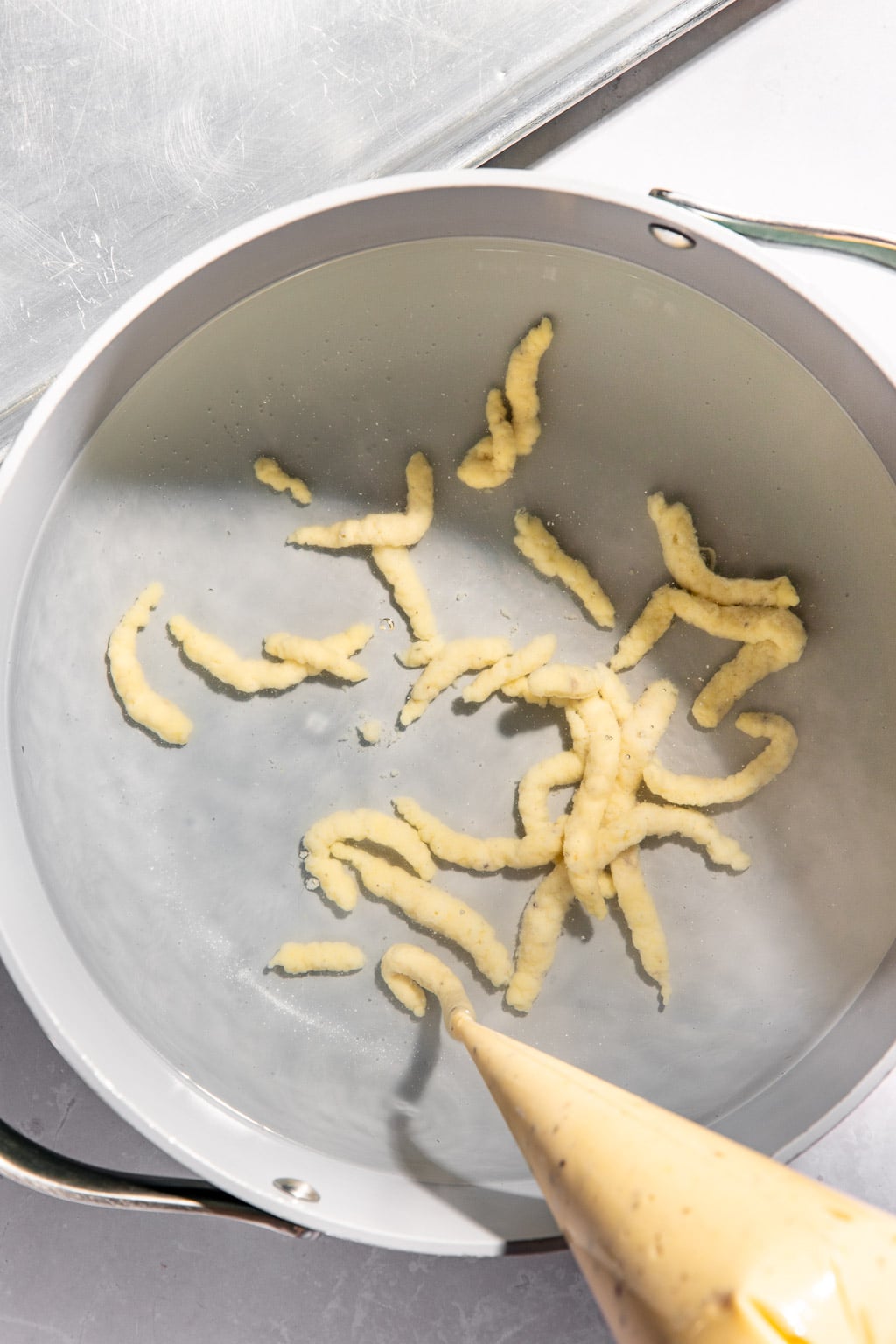 spaetzle being piped into water