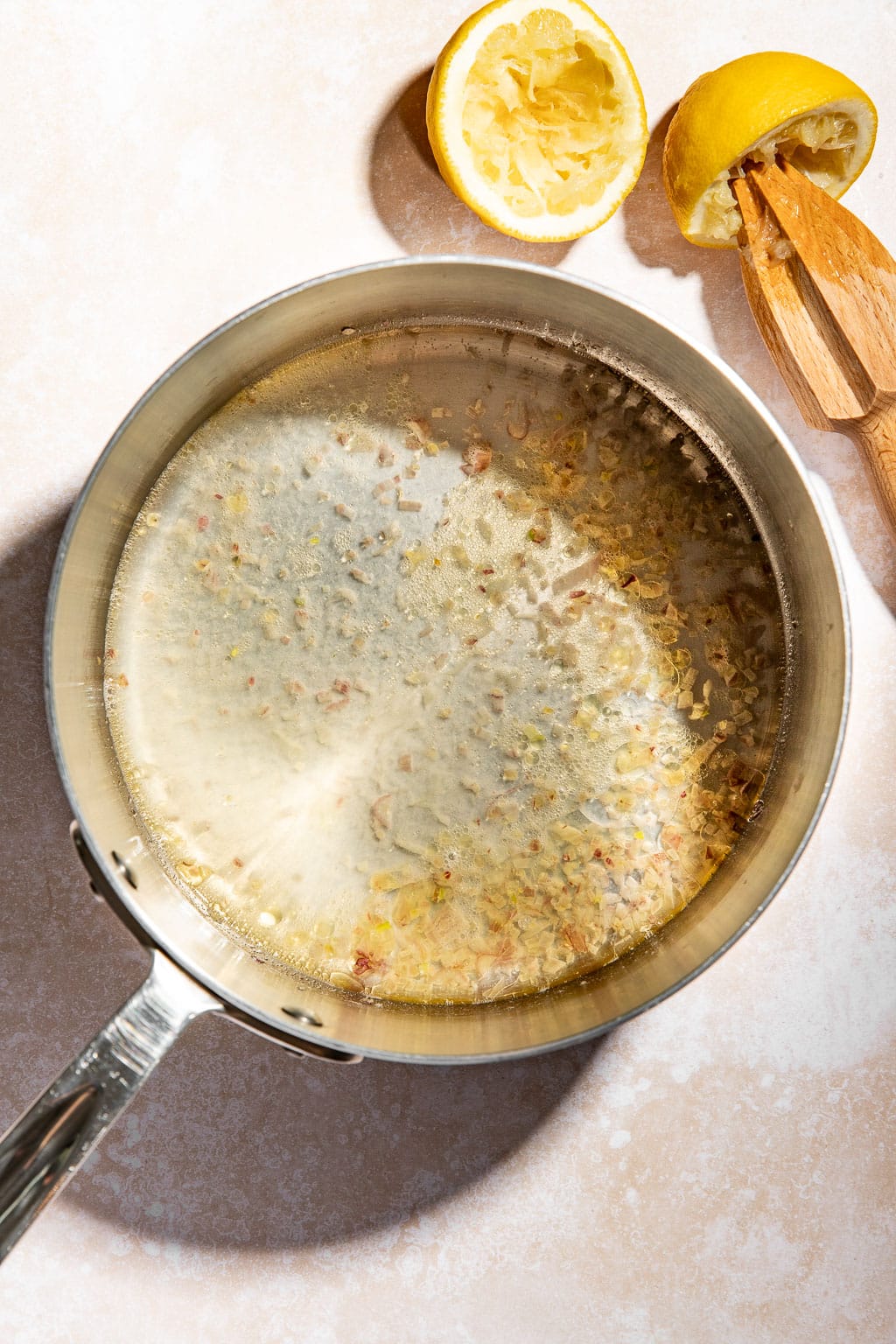 Wine reducing in a small saucepan with shallots