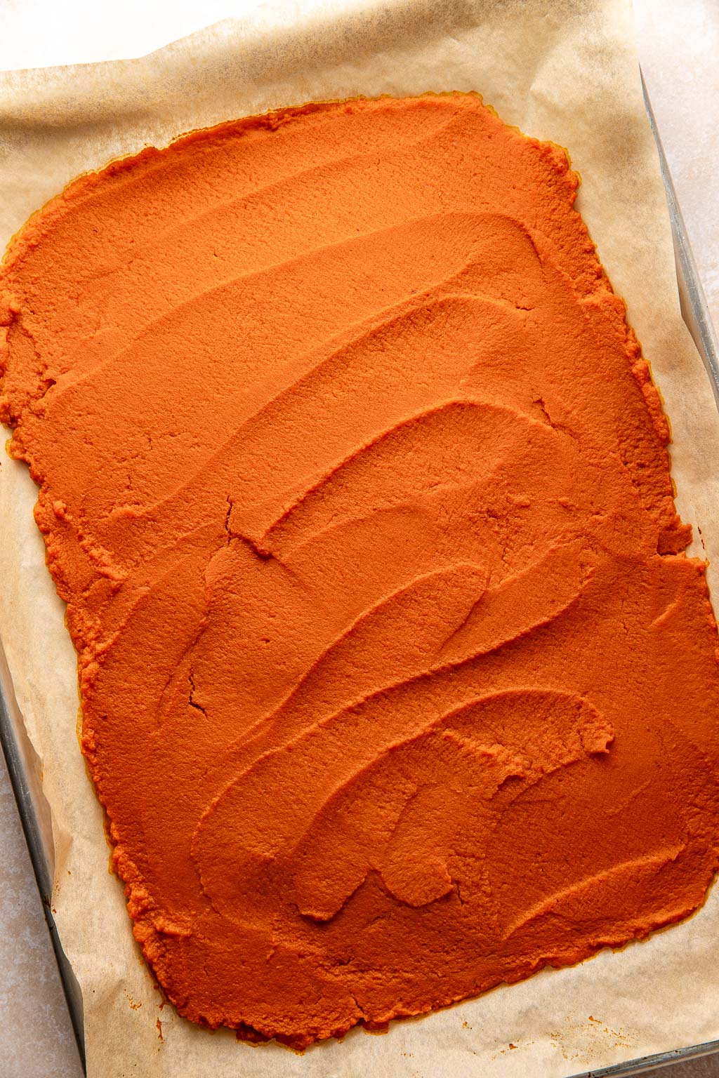 pumpkin puree spread on a baking sheet after baking