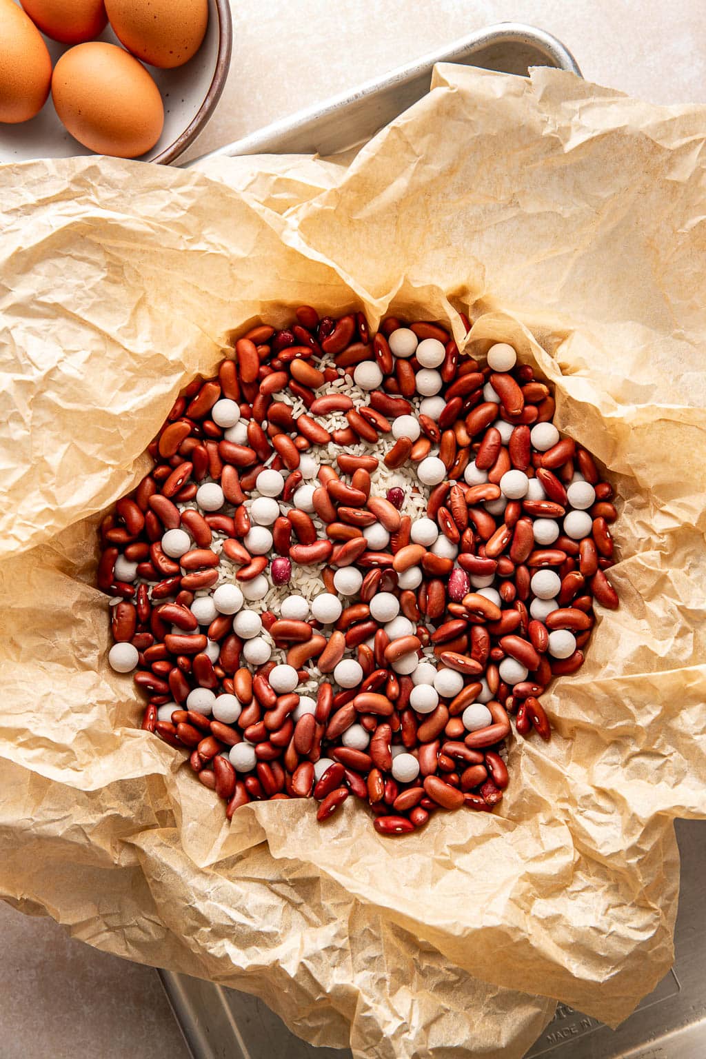 parchment paper in pie crust filled with dried beans and rice before baking