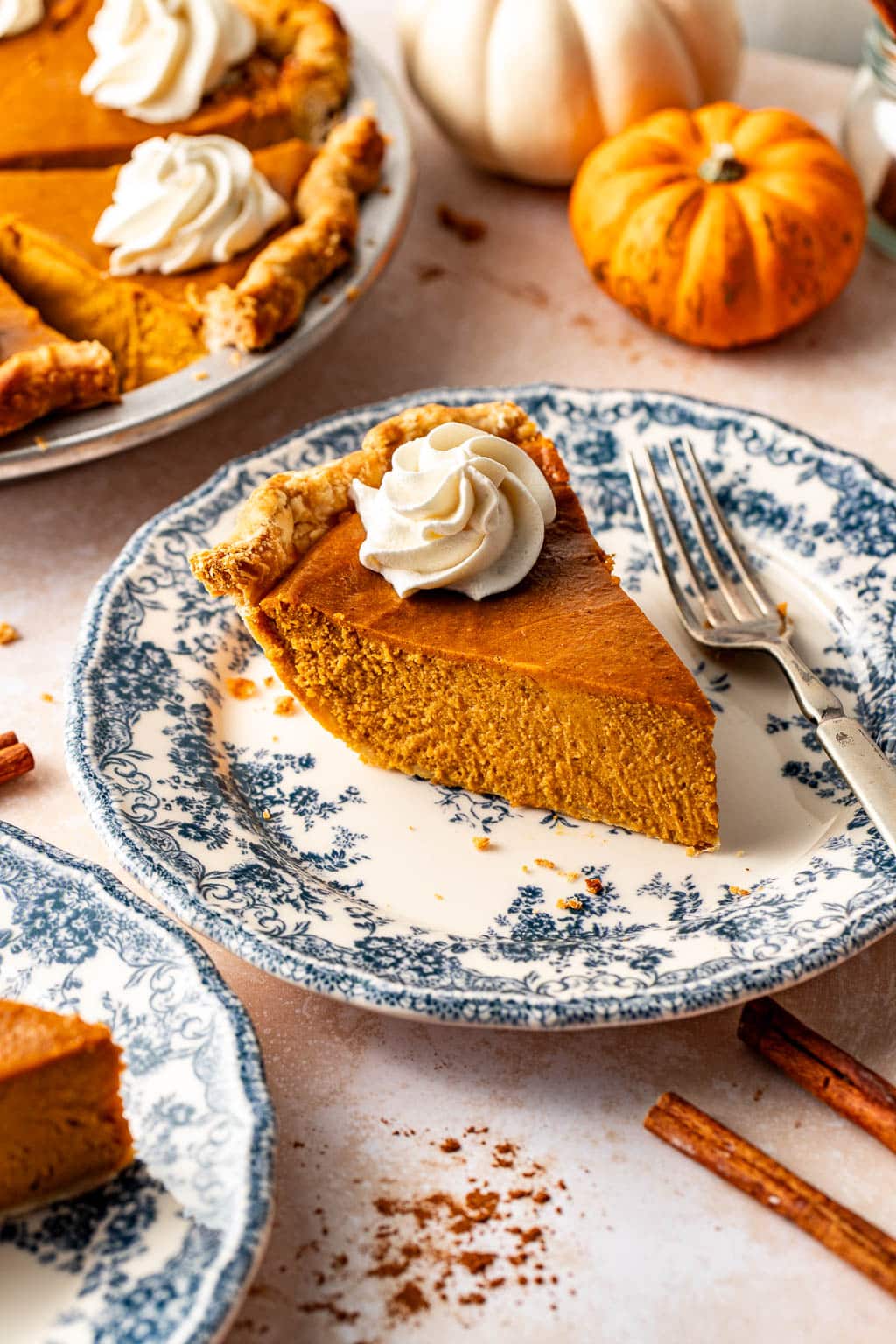 a silky smooth slice of pumpkin pie on a decorative plate.