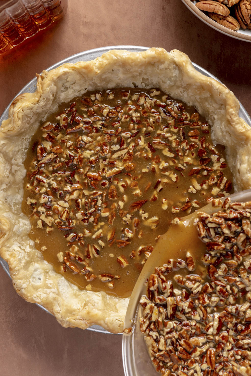 pecan pie filling being poured into the prepared pie crust