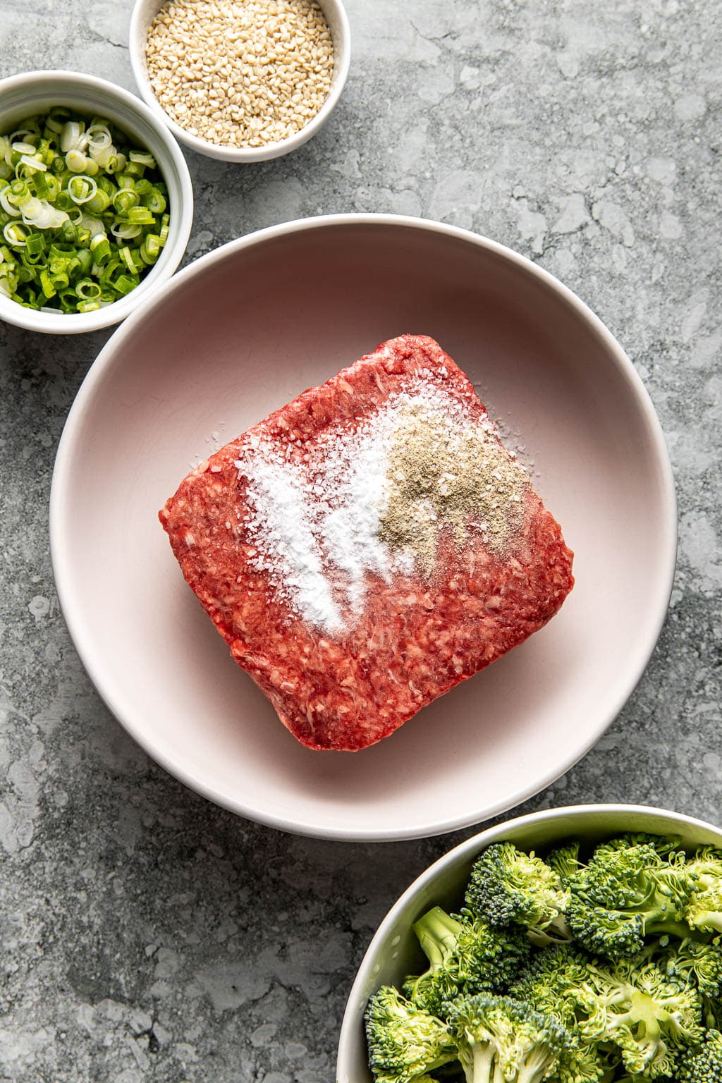 Ground beef in a bowl with baking soda, salt, and white pepper