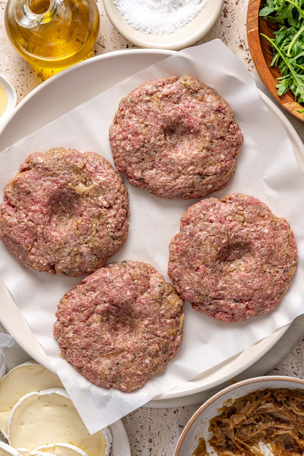 burger patties on a tray before grilling