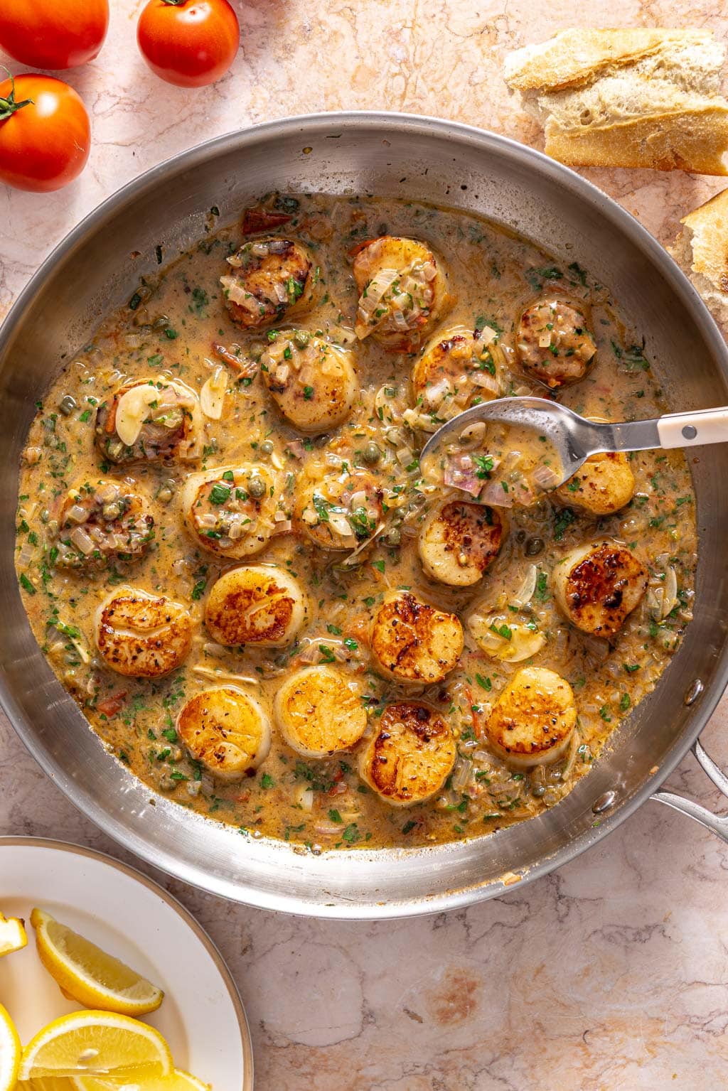scallops being topped with the pan sauce