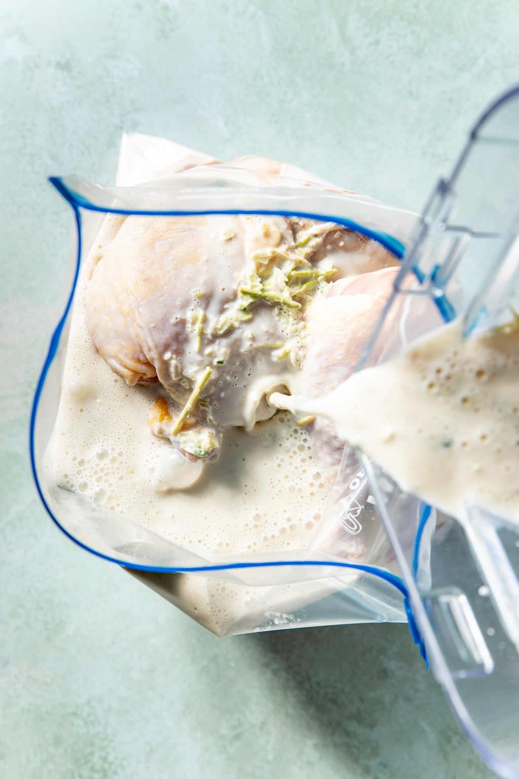 brine being poured over chicken in a ziplock bag