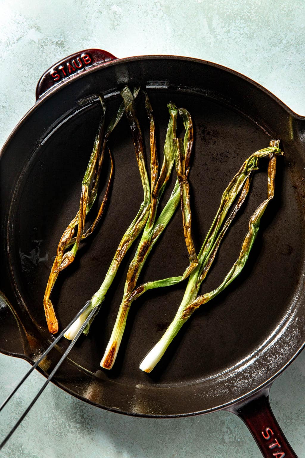 charred scallions in a cast iron pan