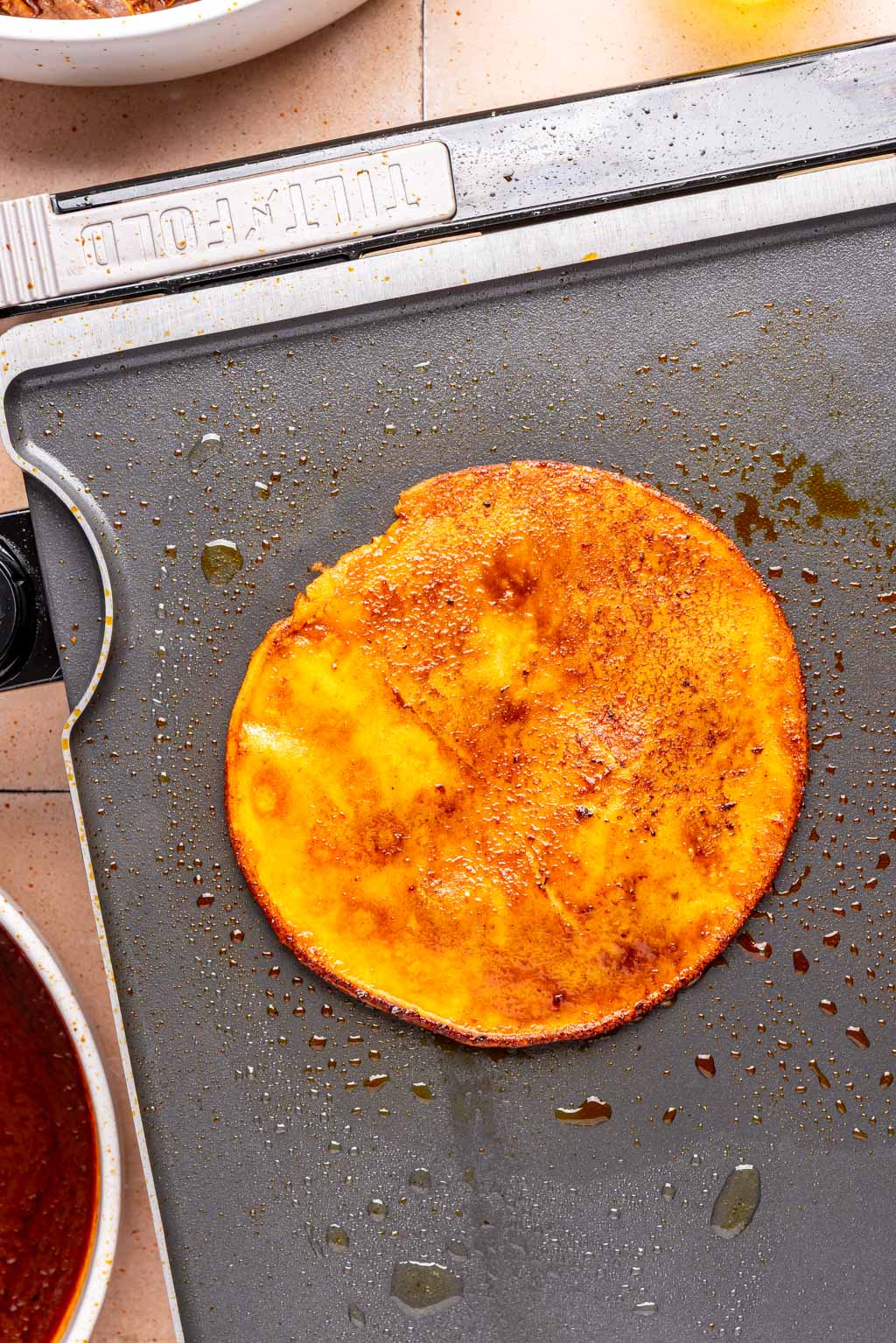 corn tortilla on a griddle cooking