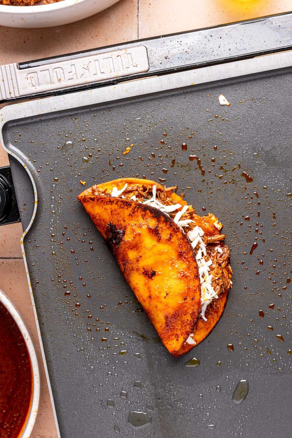 crispy birria taco on a griddle after being folded