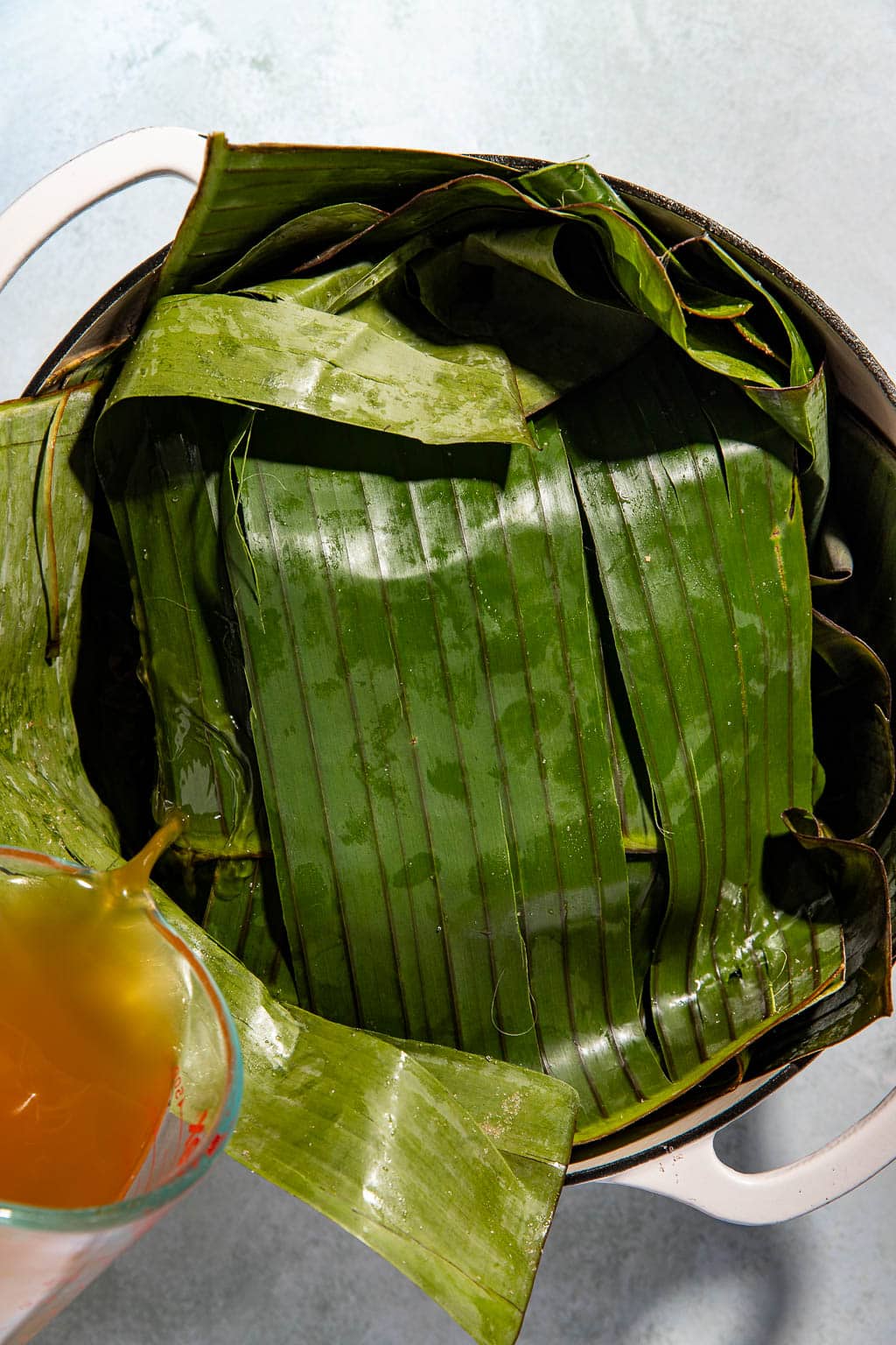 wrapped pork in banana leaves in a dutch oven