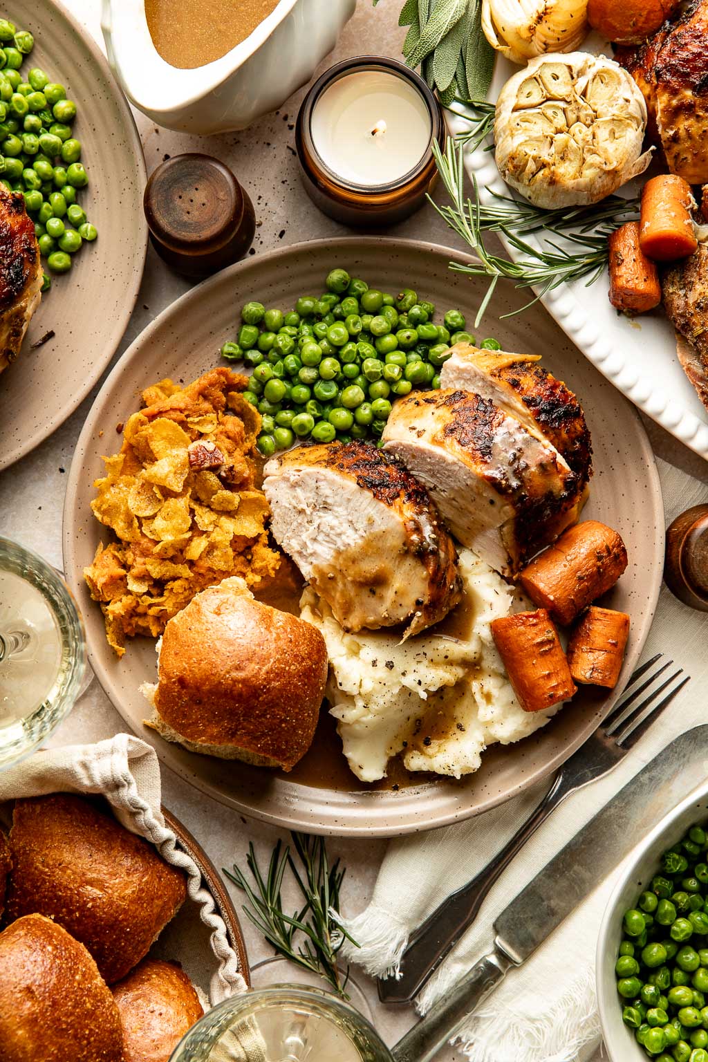 a plate of turkey dinner surrounded by holiday sides