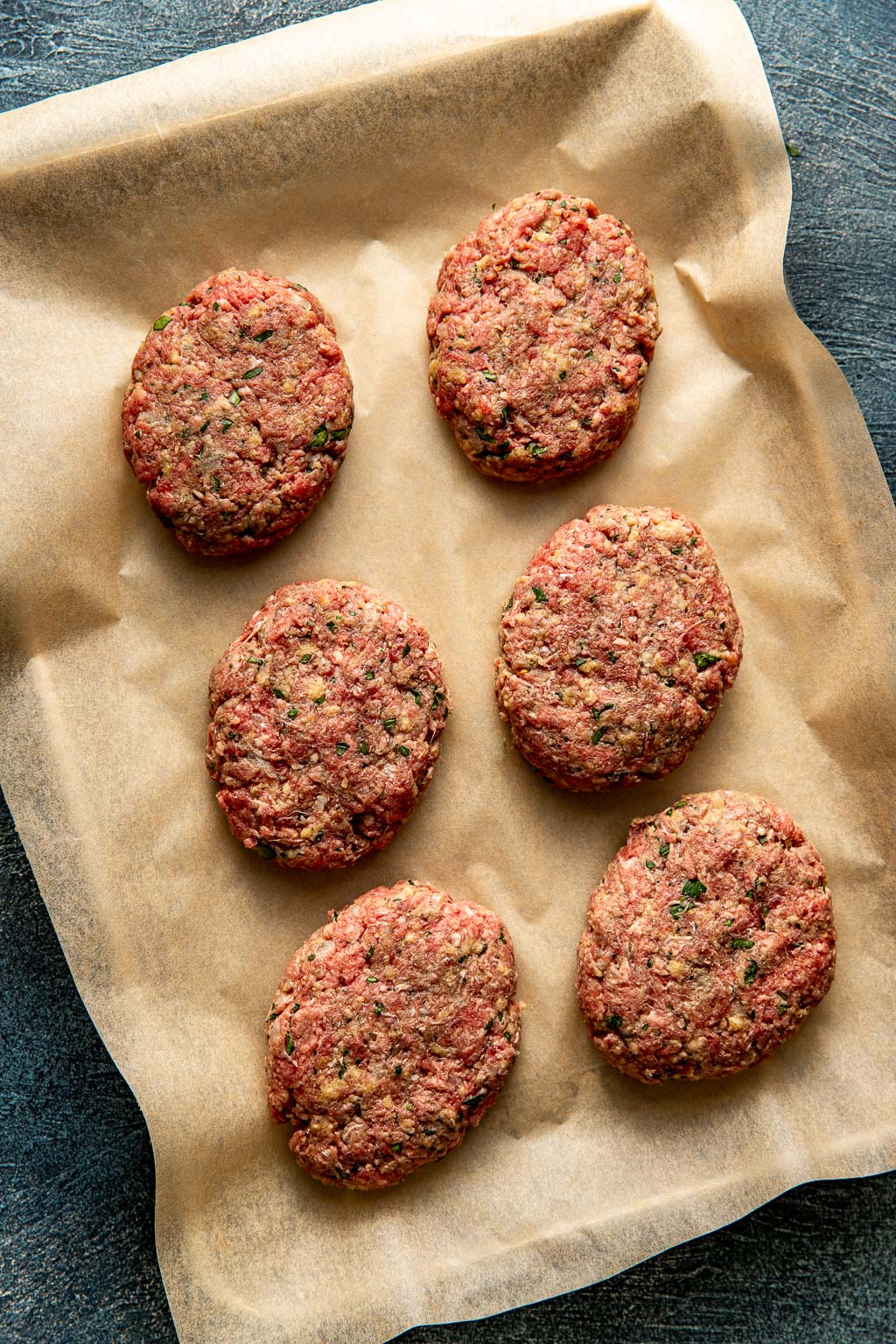 Shaped salisbury steak patties on a baking sheet before cooking